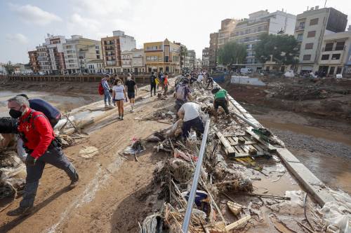 Decenas de voluntarios trabajan para despejar uno de los puentes de Paiporta