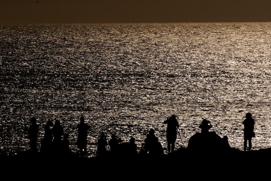 Decenas de personas observan el eclipse de sol visto desde la playa de Doniños en Ferrol este miércoles. / EFE - Kiko Delgado